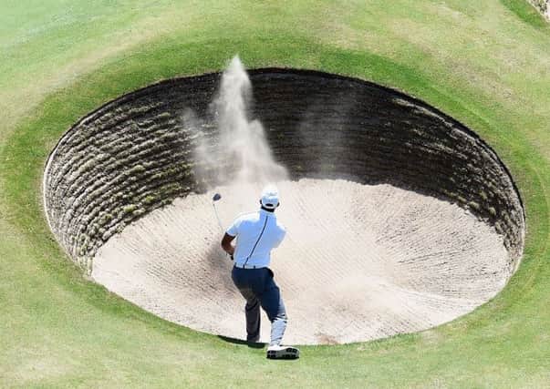 Tiger Woods chips from a bunker on to the 18th green on his way to an opening 69. Picture: Getty