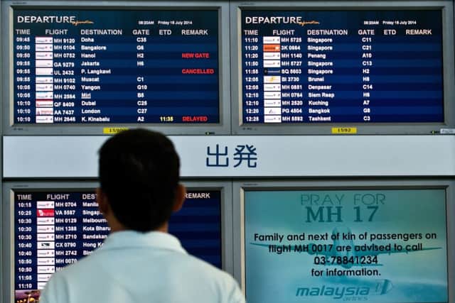 A Malaysian man looks at flight information screens in Kuala Lumpur International Airport. Picture: Getty