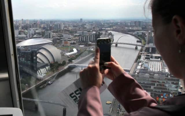A women takes a picture of the view from the newly re-opened Glasgow Tower. Picture: SWNS