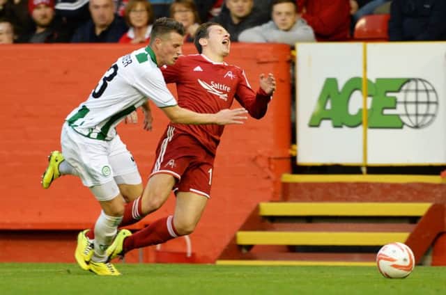 Peter Pawlett shows his displeasure as his progress is halted by Hans Hateboer of FC Groningen on Thursday night. Picture: SNS