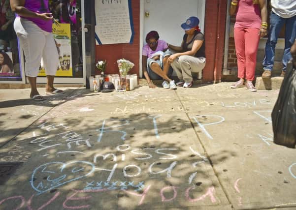 Jewel Miller, seated left, is comforted by a friend as she and her three-month-old daughter Legacy sit next to a memorial scene for Legacy's father, Eric Garner. Picture: AP