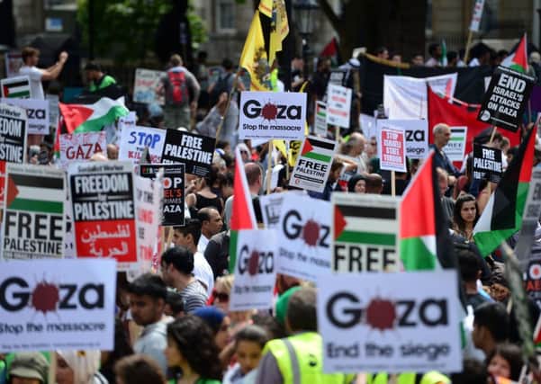 Protesters display placards and banners as they take part in demonstration against Israeli airstrikes in Gaza in central London. Picture: Getty