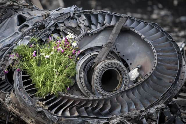 Wildflowers are placed on a plane engine at the crash site. Picture: AP