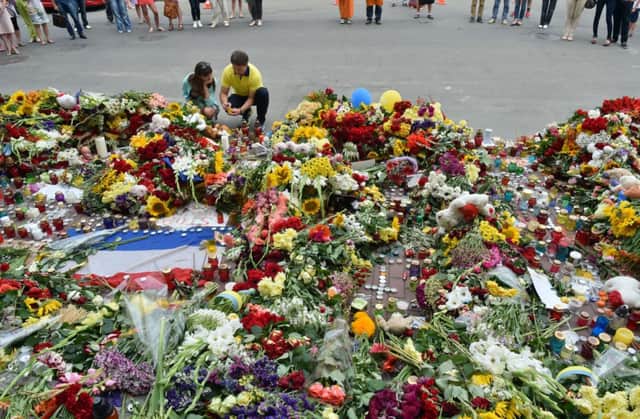 People lay flowers and light candles in front of the Embassy of the Netherlands in Kiev a day after a Malaysian Airlines flight MH17 crashed. Picture: Getty