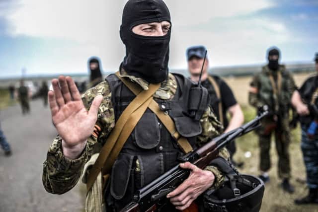 An armed pro-Russian separatist gestures as he blocks the way to the crash site. Picture: AFP/Getty