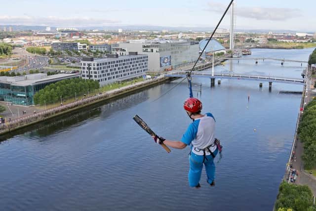The Glasgow 2014 Queen's Baton being carried across the Clyde on a zip wire from Finnieston Crane in Glasgow. Picture: PA