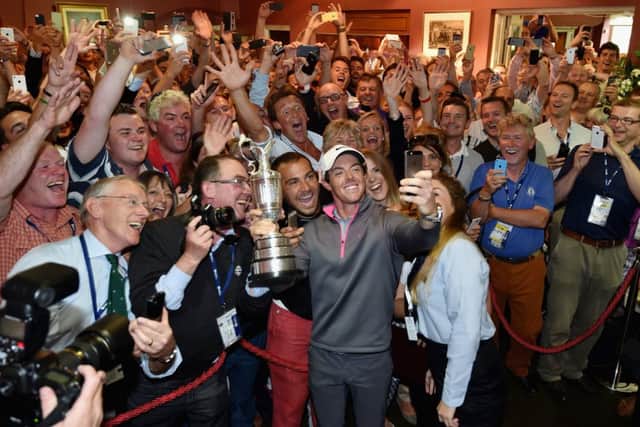 Rory McIlroy, backed by members of the Royal Liverpool, takes a selfie holding the Claret Jug. Picture: Getty