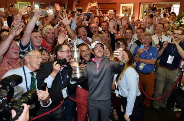Rory McIlroy, backed by members of the Royal Liverpool, takes a selfie holding the Claret Jug. Picture: Getty