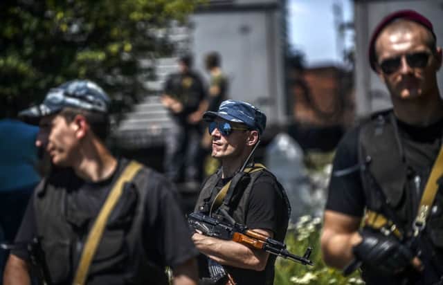 Pro-Russian separatists stand guard in front of wagons containing the remains of victims from MH17. Picture: Getty
