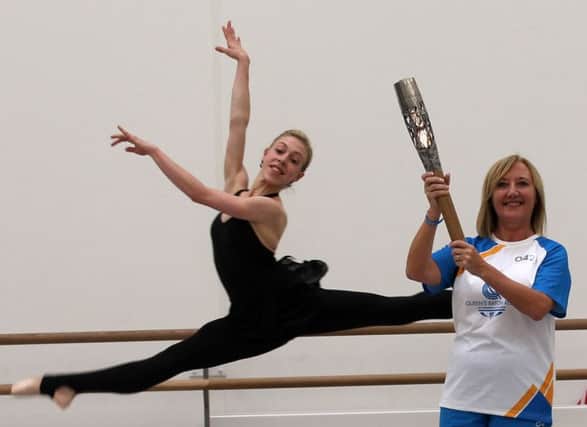 Baton-bearer Denise Holmes and a Scottish Ballet dance. Picture: PA