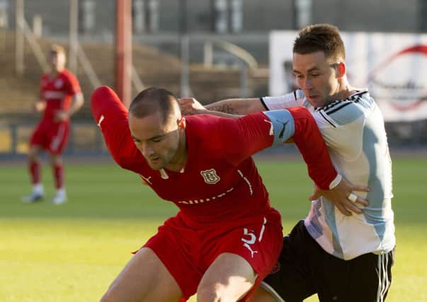 Dundee captain James McPake holds off Hearts striker James Keatings at Dens Park. Picture: SNS