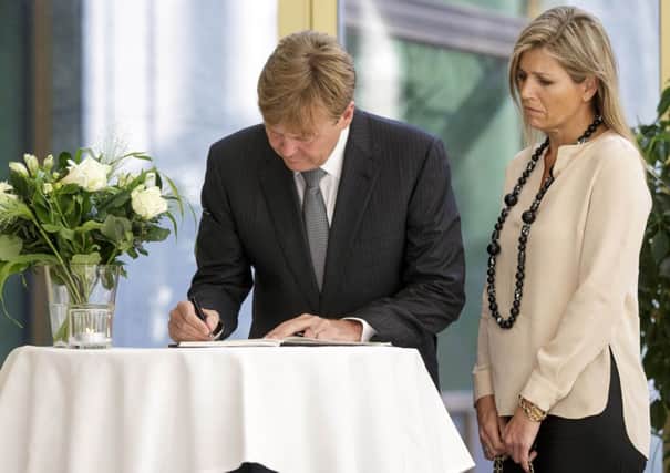 Dutch King Willem-Alexander, left, signs a condolence register as Queen Maxima looks on. Picture: AP