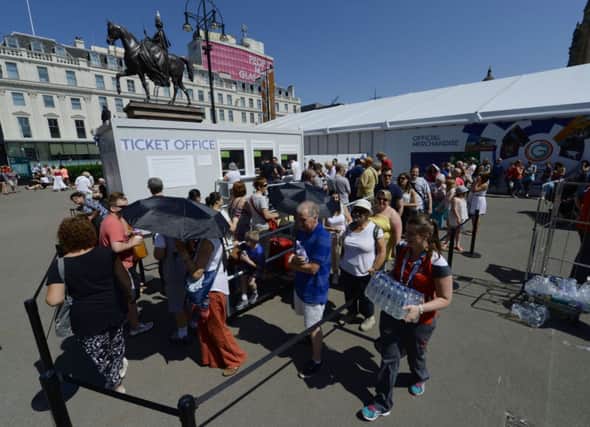 Volunteers hand out free water to people queueing to buy tickets in George Square yesterday. Picture: PA