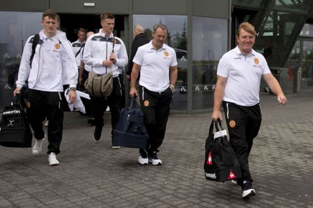 Motherwell manager Stuart McCall (right) leads his side onto the team bus after arriving in Iceland. Picture: SNS