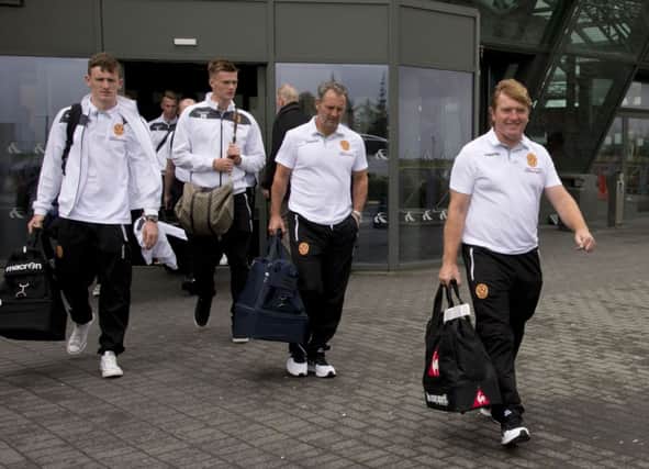 Motherwell manager Stuart McCall (right) leads his side onto the team bus after arriving in Iceland. Picture: SNS