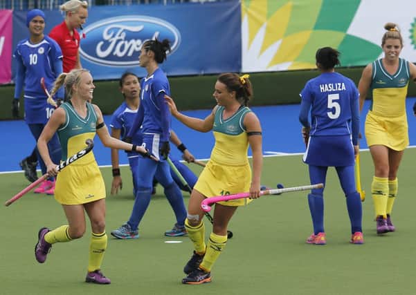 Australia's Georgina Parker, center, celebrates after scoring  during the hockey match between Australia and Malaysia. picture: AP