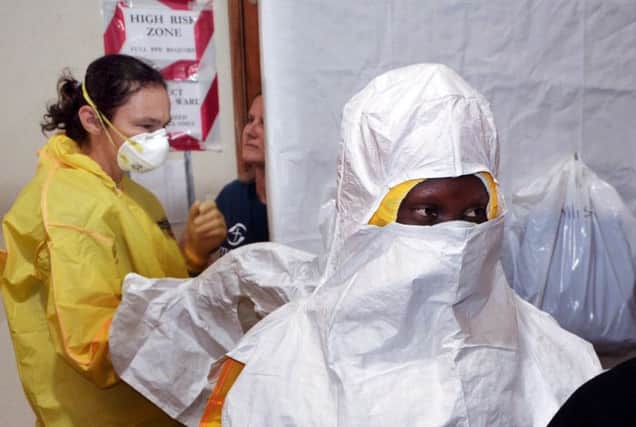 Staff at the Christian Samaritans Purse treatment centre put on gear that will protect them against the deadly Ebola. Picture: Getty