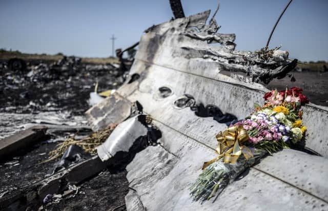 Flowers were left on a piece of the wreckage of the Malaysia Airlines plane by parents of a victim of the crash. Picture: Getty