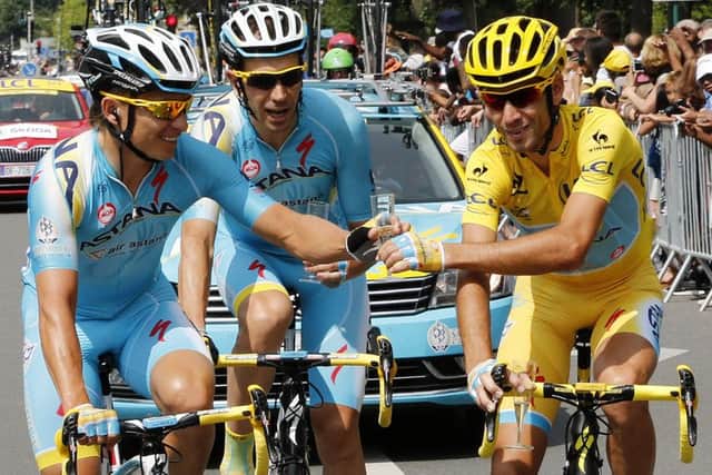 Italys Vincenzo Nibali, right, wearing the overall leaders yellow jersey toasts champagne with his team-mates. Picture: AFP/Getty