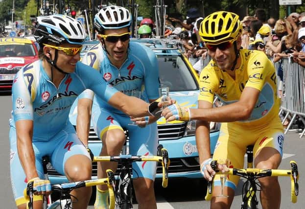 Italys Vincenzo Nibali, right, wearing the overall leaders yellow jersey toasts champagne with his team-mates. Picture: AFP/Getty