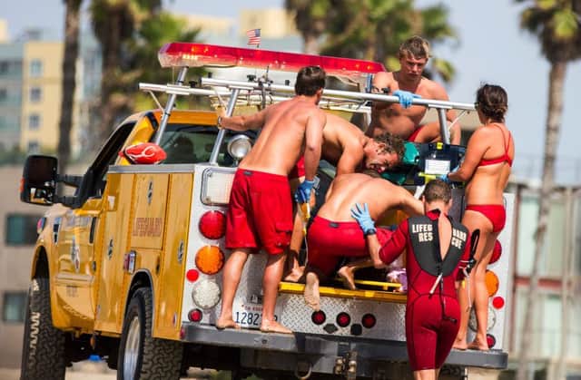 Lifeguards help some of those struck by lightening on Venice Beach. Picture: AP