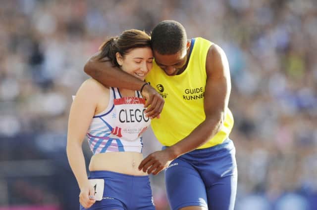 Libby Clegg celebrates her victory last night with her running guide Mikail Huggins. Picture: Greg Macvean