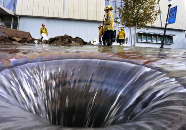 Firefighters open a storm drain to release the floodwaters. Picture: Reuters