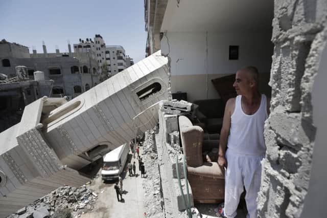 Ismail Radwan inspects the damage to his home caused by a fallen minaret of the Al-Sousi mosque. Picture: AP