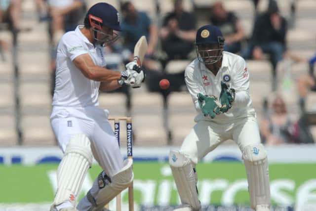 Alastair Cook shapes to cut, watched by Indian captain and wicketkeeper MS Dhoni. Picture: Getty