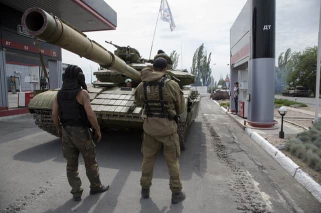 Donetsk People's Republic fighters fill their tank with fuel at a gas station in Snizhne. Picture: AP