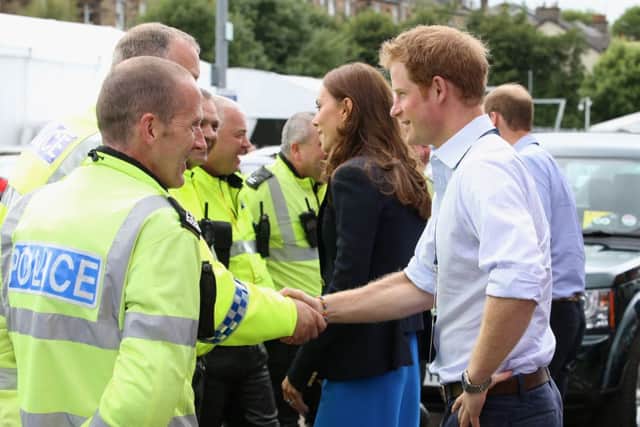 It's all smiles as Prince Harry chats with the Police outside Hampden, but Police complaints about shifts during the Games are rising. Picture: Getty