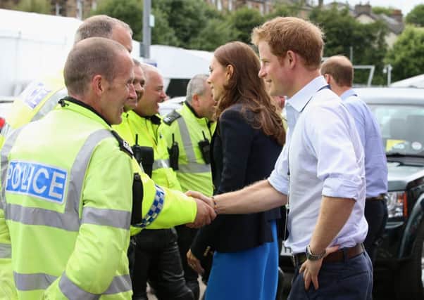 It's all smiles as Prince Harry chats with the Police outside Hampden, but Police complaints about shifts during the Games are rising. Picture: Getty