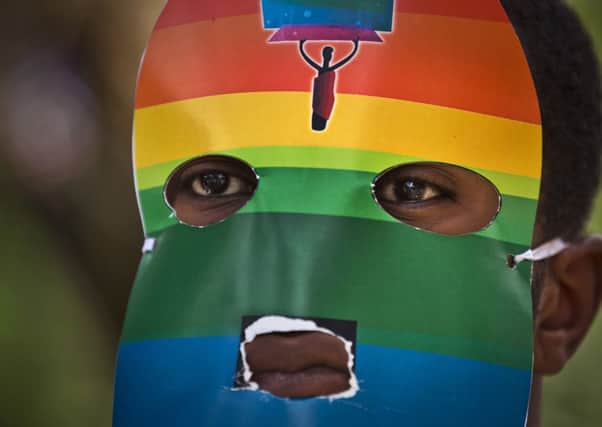 A Kenyan gay wears a mask to preserve his anonymity as they stage a rare protest outside the Uganda High Commission in Nairobi, Kenya. Picture: AP