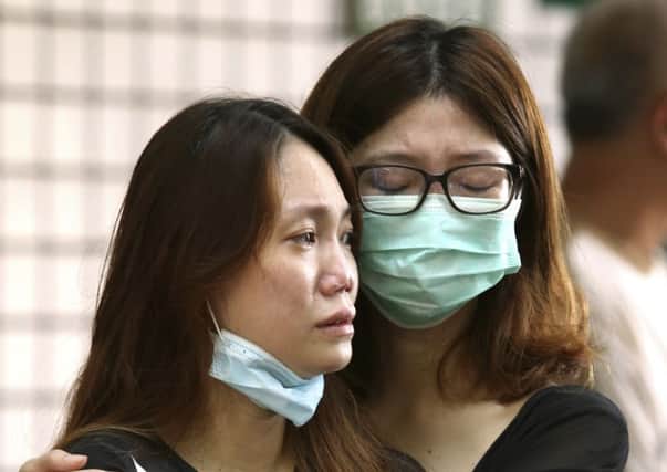 Relatives of victims in a series of gas explosions console each other at a funeral parlor in Kaohsiung, Taiwan. Picture: AP