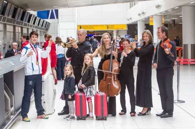 Scottish judo gold medalist Sarah Clark conducts the RSNO at Glasgow Airport. Picture: PA