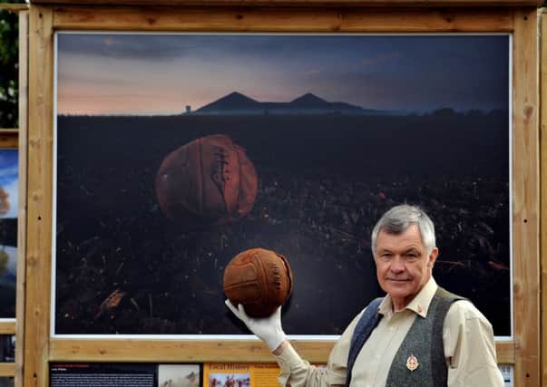 Michael St Maur Sheil, holds the Loos Football in front of his painting of the battle Picture: Scott Louden