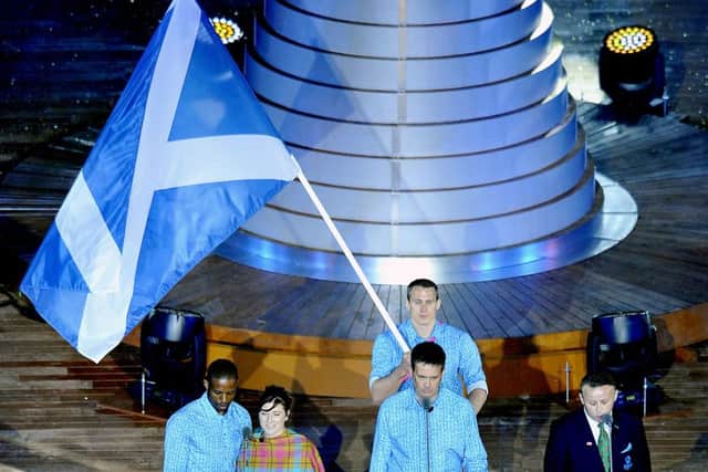 The flag being carried aloft at the opening ceremony, now officials must choose who carries it for the closing ceremony. Picture: TSPL
