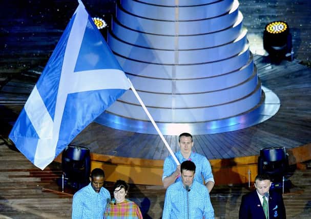 The flag being carried aloft at the opening ceremony, now officials must choose who carries it for the closing ceremony. Picture: TSPL