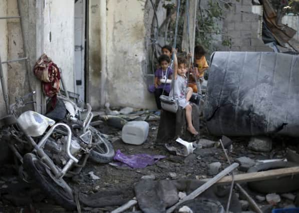 A girl sits on a swing outside her house, which witnesses said was damaged in an Israeli air strike. Picture: Reuters