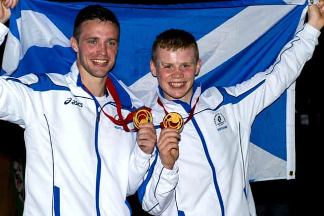Josh Taylor and Charlie Flynn raise the Saltire after their medal-winning performances. Picture: SNS