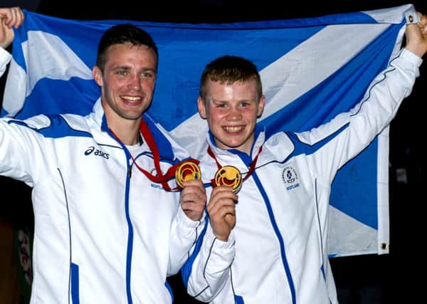 Josh Taylor and Charlie Flynn raise the Saltire after their medal-winning performances. Picture: SNS