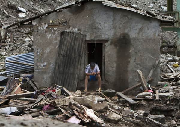 A Nepalese boy waits in the ruins for news of his missing family. Picture: AP