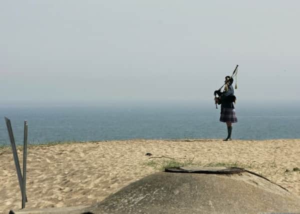 A lone Canadian Armed Forces piper plays during ceremonies marking the 60th Anniversary of D-Day at Juno Brach. Picture: Reuters