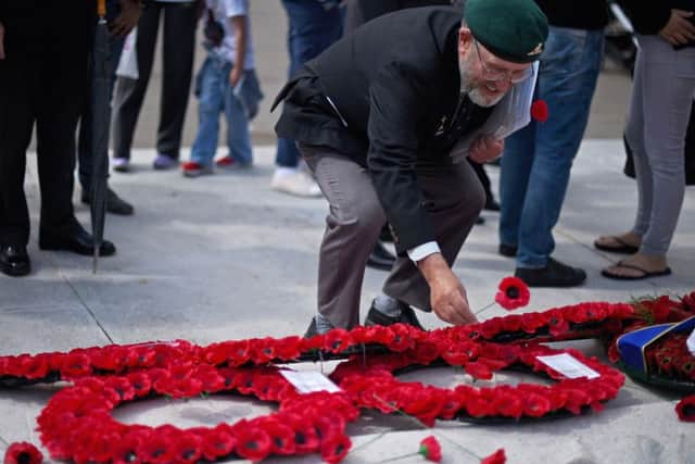 A former serviceman lays a poppy at George Square. Picture: Getty