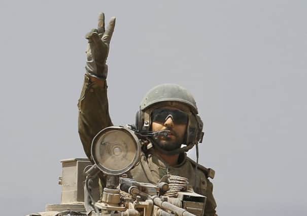 An Israeli soldier flashes the V-sign for "Victory" on board his Israeli Merkava tank near the border between Israel and the Gaza Strip. Picture: Getty
