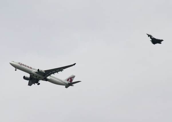 A military fighter jet escorts the passenger jet as it comes in to land at Manchester airport, Manchester. Picture: AP