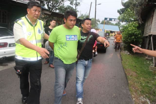 Police in Kuching arrest one of the four men suspected of killing the students. It is believed the murders were prompted by an argument in a bar. Picture:  Barcroft India