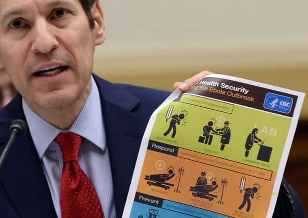 CDC Director Tom Frieden shows an "Combating the Ebola Threat" awareness poster. Picture: Getty
