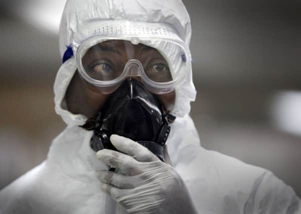 A Nigerian health official wearing a protective suit waits to screen passengers at the arrivals hall of Murtala Muhammed International Airport in Lagos, Nigeria. Picture: AP