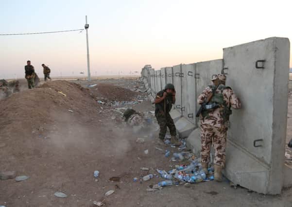 Kurdish Peshmerga fighters take cover during airstrikes targeting Islamic State militants near the Khazer checkpoint. Picture: AP